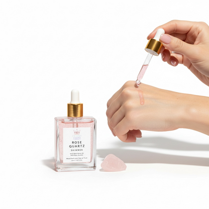 Rose Quartz essential oil bottle with dropper and hand holding it on a white background